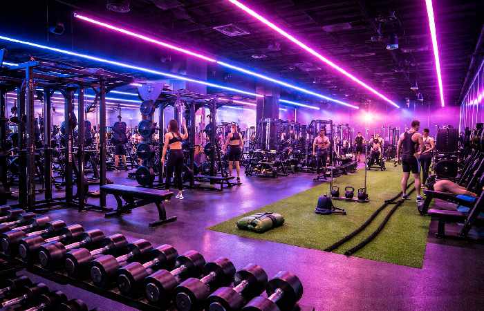 gym floor with strength machines dumbbells and functional training area