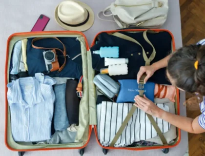 Person packing a suitcase with travel essentials