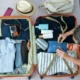 Person packing a suitcase with travel essentials